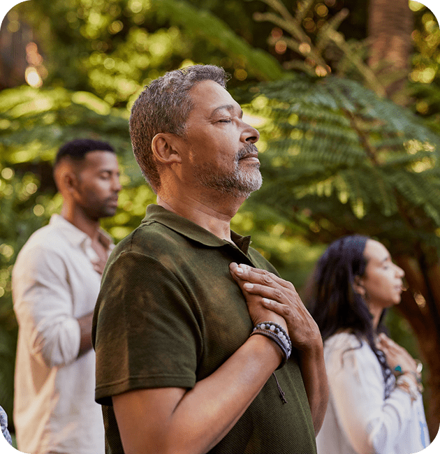 People meditating outdoors in a peaceful setting.